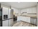 Bright kitchen featuring white cabinetry, stainless steel appliances, and wood-look vinyl flooring at 3351 Landrum Se Dr, Smyrna, GA 30082