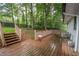 Spacious wooden deck off the back of house with stairs and a wooded backyard at 7505 Rico Rd, Chattahoochee Hills, GA 30268