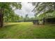 Expansive backyard featuring green grass, large trees, and black horse fencing at 7505 Rico Rd, Chattahoochee Hills, GA 30268