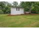 Lush green yard with mature trees surrounding a charming white house at 7505 Rico Rd, Chattahoochee Hills, GA 30268