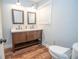 Bright bathroom featuring a double sink vanity with hardwood flooring and modern fixtures at 7505 Rico Rd, Chattahoochee Hills, GA 30268