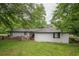 Charming white brick home with a cozy wooden deck surrounded by lush greenery at 7505 Rico Rd, Chattahoochee Hills, GA 30268