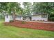 This home includes a large yard, driveway, and an attached garage with a well-manicured lawn at 7505 Rico Rd, Chattahoochee Hills, GA 30268