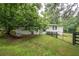 Well-maintained white house with mature trees and a green lawn at 7505 Rico Rd, Chattahoochee Hills, GA 30268