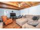 Relaxing living room with a large TV, comfortable seating and wood-beamed ceiling at 7505 Rico Rd, Chattahoochee Hills, GA 30268