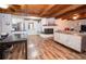 Open living room with wood-beamed ceilings, fireplace and new floors at 7505 Rico Rd, Chattahoochee Hills, GA 30268