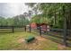 Property featuring a fenced yard, a red barn, and a separate small shed at 7505 Rico Rd, Chattahoochee Hills, GA 30268