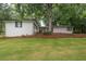 A large yard features well-maintained lawn and perimeter landscaping with mature trees at 7505 Rico Rd, Chattahoochee Hills, GA 30268