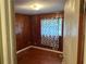 Bedroom with wood paneling and wood floors, featuring a window dressed with a blue and grey curtain at 1681 Sw Hammond Woods Sw Cir, Marietta, GA 30008