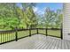 A cozy back deck with black railings, overlooking a yard and greenery beyond at 327 Oakland Bay Ct, Loganville, GA 30052
