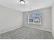 This bedroom offers plush carpets, neutral paint, and a window that faces the backyard at 327 Oakland Bay Ct, Loganville, GA 30052