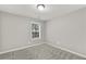 This bedroom features neutral paint, plush carpets, and a window for natural light at 327 Oakland Bay Ct, Loganville, GA 30052