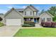 Beautiful two-story home featuring a manicured lawn, charming shutters and a blue front door at 327 Oakland Bay Ct, Loganville, GA 30052