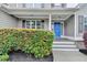 Charming front porch featuring a bright blue door surrounded by lush green bushes at 327 Oakland Bay Ct, Loganville, GA 30052
