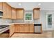 View of kitchen features stainless steel dishwasher and view to the backyard at 327 Oakland Bay Ct, Loganville, GA 30052