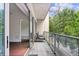 Cozy balcony featuring patio furniture, hardwood floors, glass railing, and an open view of nearby trees at 1100 Howell Mill Nw Rd # 212, Atlanta, GA 30318