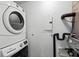 This laundry room features a stacked washer and dryer, utility connections, and fuse panel at 1100 Howell Mill Nw Rd # 212, Atlanta, GA 30318