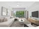 Modern living room with a plush couch, hardwood floors, a ceiling fan, and a large window view at 1100 Howell Mill Nw Rd # 212, Atlanta, GA 30318