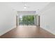 An empty living room featuring hardwood floors, neutral paint, and large glass patio doors at 1100 Howell Mill Nw Rd # 212, Atlanta, GA 30318
