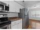 A view of the kitchen with stainless steel refrigerator and view into an adjoining room at 1150 Collier Nw Rd # 6H, Atlanta, GA 30318