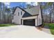 Exterior view showcasing white brick, a black garage door, and professional landscaping at 1820 Lake Dow Rd, Mcdonough, GA 30252