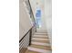 Modern staircase with wood treads, black metal railing, and a stylish light fixture at 1820 Lake Dow Rd, Mcdonough, GA 30252