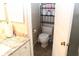 A bathroom with a tiled floor, vanity, toilet, and accessories displayed on shelves at 5574 Mccrossin Cir, Lithonia, GA 30038