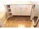 A white bathroom vanity with drawers, shelves, tile flooring, and a view of a soaking tub at 5574 Mccrossin Cir, Lithonia, GA 30038