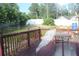 Exterior view of a wooden deck with railings, a table, and lush green trees at 5574 Mccrossin Cir, Lithonia, GA 30038