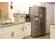 Well-lit kitchen features stainless steel refrigerator, sleek countertops and white cabinets for a bright cooking space at 5574 Mccrossin Cir, Lithonia, GA 30038
