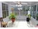 A bright sunroom with tile flooring, windows, ceiling fan and potted plants at 5574 Mccrossin Cir, Lithonia, GA 30038