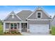 Charming one-story home with a two-car garage, stone accents, and a cozy front porch with seating at 18 Torry Pines Cir, Villa Rica, GA 30180