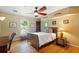 Cozy bedroom with hardwood floors, ceiling fan, and a window providing natural light at 4820 Coppedge Trl, Duluth, GA 30096
