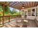 Charming outdoor patio with a pergola, outdoor dining table, and seating area overlooking lush greenery at 4820 Coppedge Trl, Duluth, GA 30096