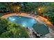 Stunning outdoor pool area with lounge chairs, patio umbrella, and lush landscaping creating a private retreat at 4820 Coppedge Trl, Duluth, GA 30096