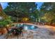 Inviting backyard pool area with patio, umbrellas, outdoor seating, and lush greenery, perfect for relaxation at 4820 Coppedge Trl, Duluth, GA 30096