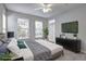 This staged bedroom features an outdoor patio door, large windows and a modern ceiling fan at 1203 Stratford Commons Commons, Decatur, GA 30030