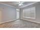 An empty bedroom with gray walls, a door to the outside, a ceiling fan, and carpeted floors at 1203 Stratford Commons Commons, Decatur, GA 30030