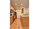 Galley style kitchen with stainless steel appliances and natural wood cabinets and flooring at 1203 Stratford Commons Commons, Decatur, GA 30030