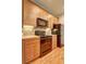 Close-up of galley-style kitchen with black appliances, wood cabinets, and tiled backsplash at 1203 Stratford Commons Commons, Decatur, GA 30030
