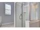 This modern shower features glass doors and white tiled walls at 1203 Stratford Commons Commons, Decatur, GA 30030