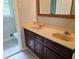Bathroom featuring double sink vanity with warm wood cabinets and classic tile floor at 2553 Country Club Dr, Conyers, GA 30013