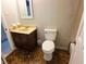 Bathroom features a toilet, sink, vanity and brown patterned flooring at 2553 Country Club Dr, Conyers, GA 30013