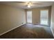 Comfortable bedroom featuring new carpet, ceiling fan and two large windows at 2553 Country Club Dr, Conyers, GA 30013