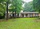 Charming two-story home with brick and siding exterior, set amidst mature trees and a lush green lawn at 2553 Country Club Dr, Conyers, GA 30013