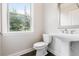 Bathroom featuring a pedestal sink, toilet, and window with natural light at 2560 Clairebrooke Bnd, Atlanta, GA 30341