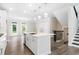 Bright kitchen featuring a large island, stainless steel appliances, and seamless flow to a dining space and staircase at 2560 Clairebrooke Bnd, Atlanta, GA 30341