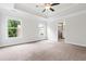 Bright main bedroom featuring plush carpet, tray ceiling, and en suite bathroom at 2560 Clairebrooke Bnd, Atlanta, GA 30341