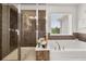 Elegant bathroom featuring a glass-enclosed shower, soaking tub, and neutral tile accents at 2921 Terra View Sw Dr, Lilburn, GA 30047