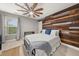 Stylish bedroom with a wood-paneled accent wall, designer ceiling fan, and ample natural light at 2921 Terra View Sw Dr, Lilburn, GA 30047